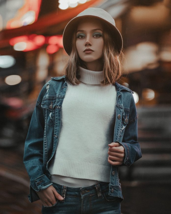 a woman in a hat is standing on the street