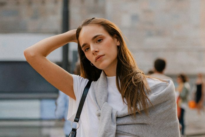 Young woman with hand in hair outdoors