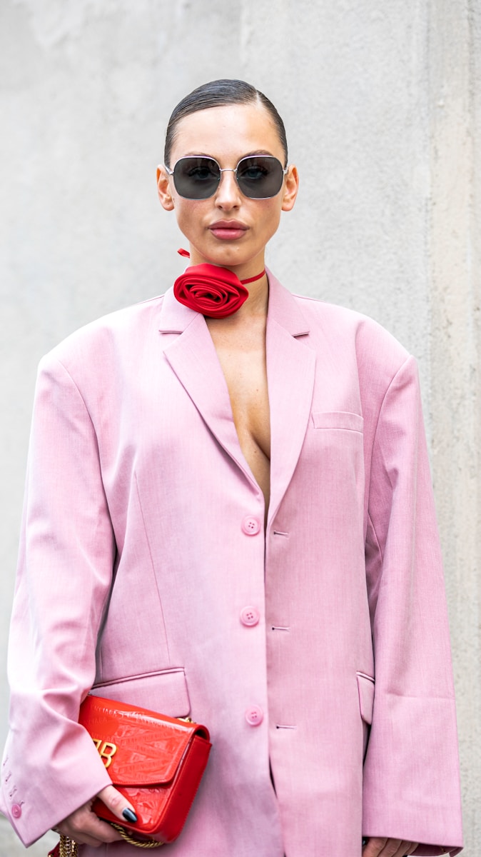 a woman wearing a pink suit and sunglasses