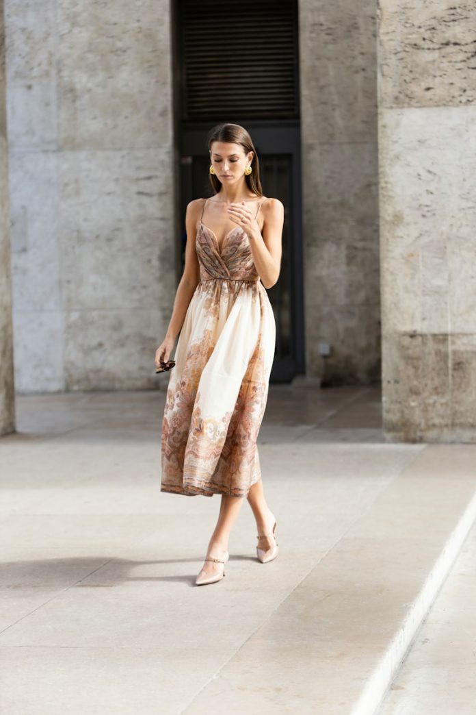 A woman in a dress is walking down the street