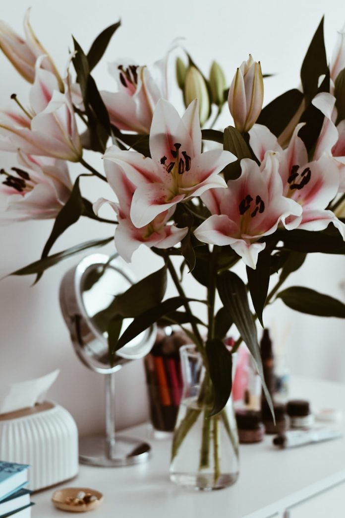 A vase filled with pink flowers on top of a white table